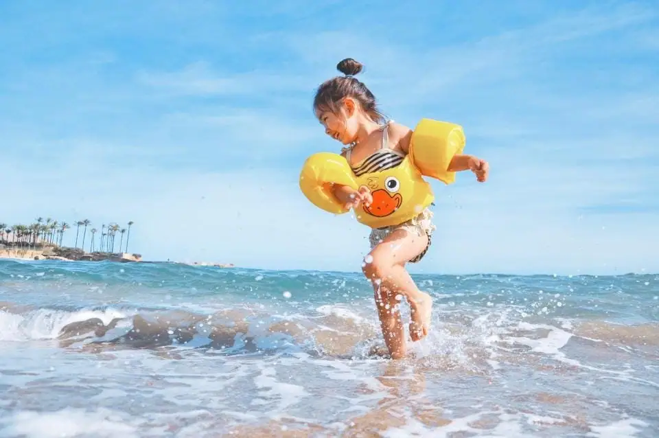 Niño jugando en el mar con flotadores