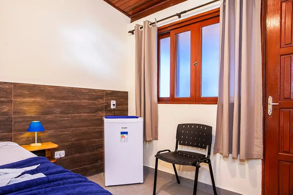 Cama king e frigobar da Suíte Standard